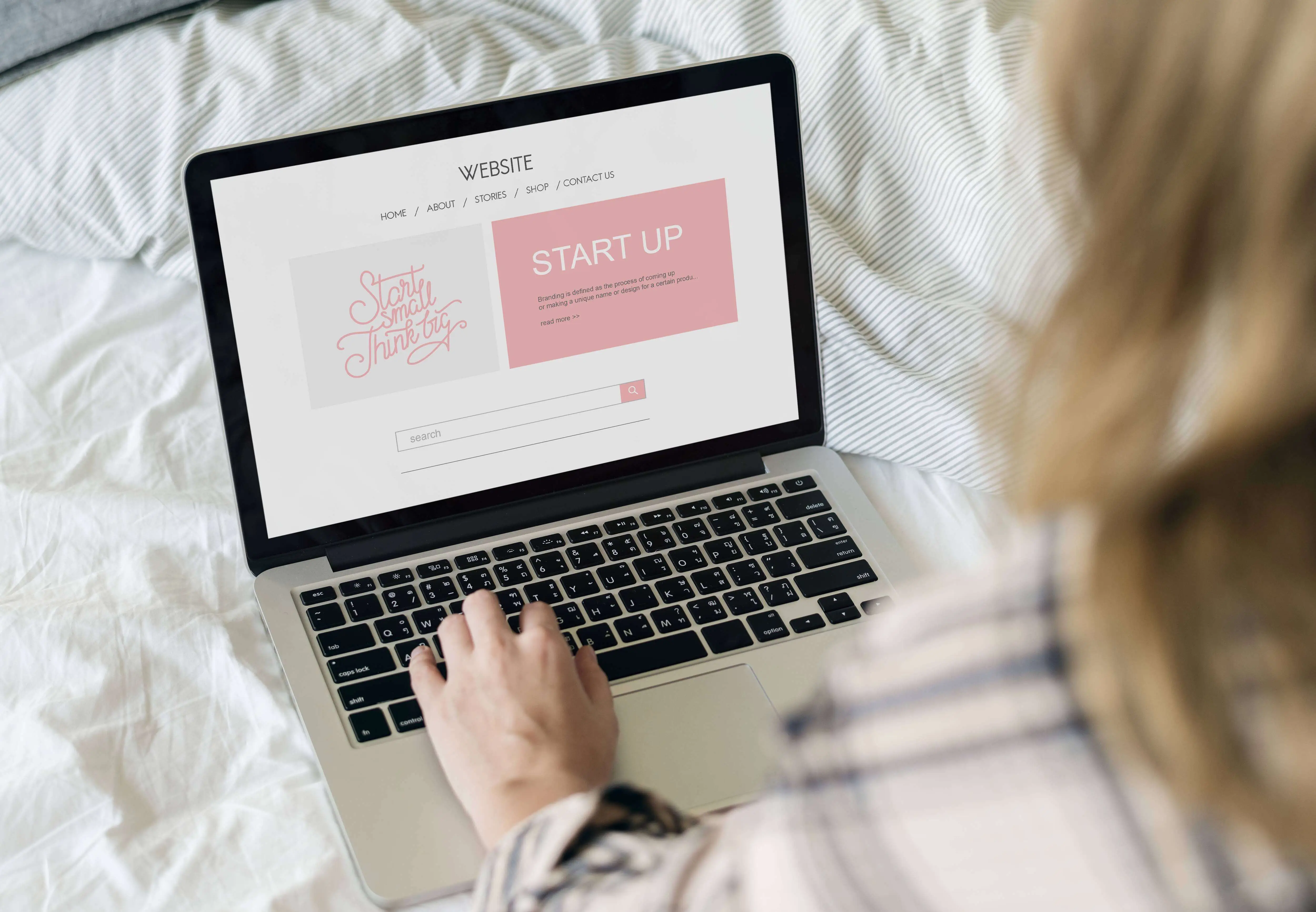 A woman in front of the laptop clicks the keyboard of her laptop